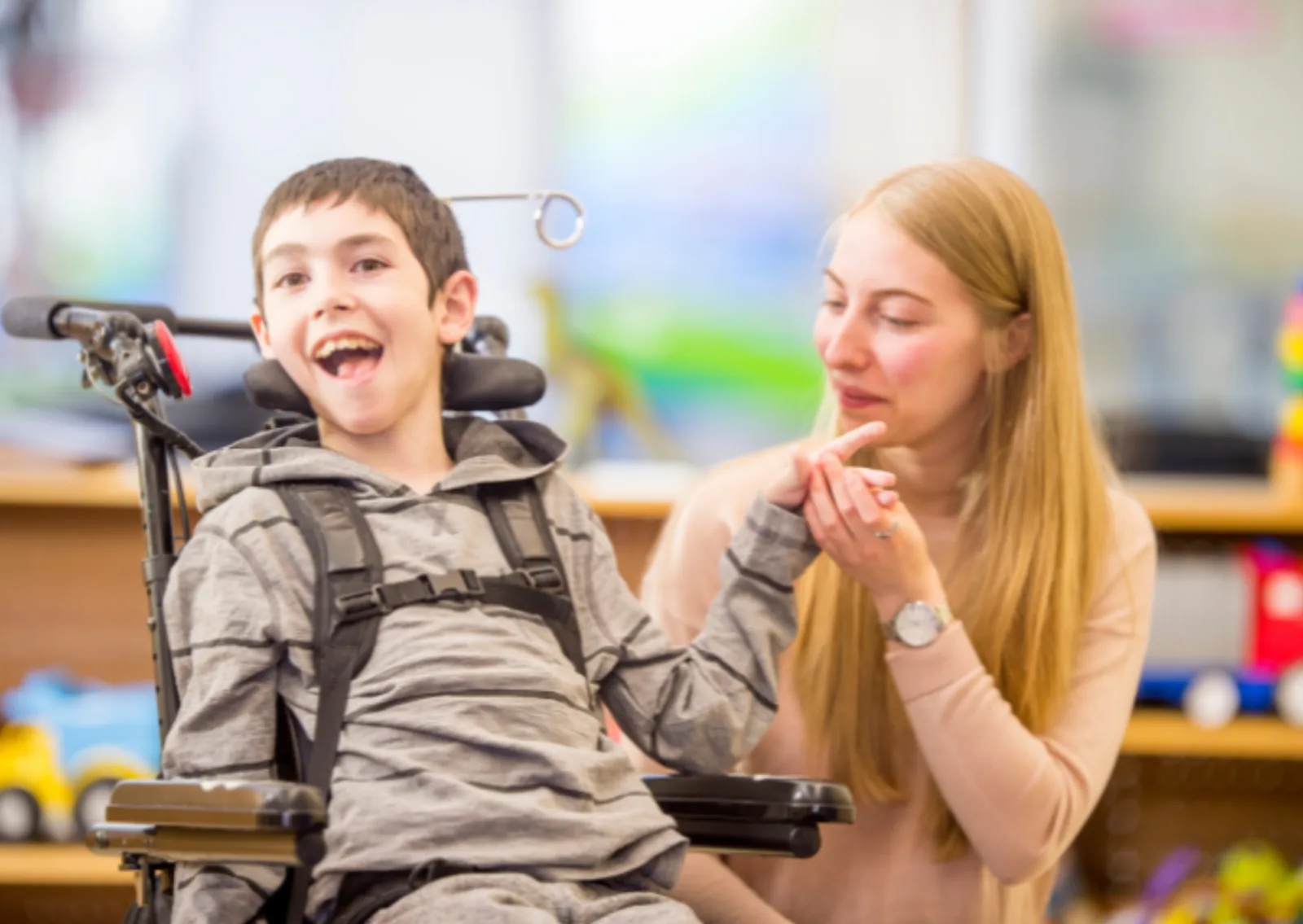 Noon Care support worker sharing a warm, calm moment with a young NDIS participant in a wheelchair during personal care assistance at home